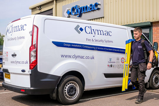 Clymac employee with step ladder next to company van.