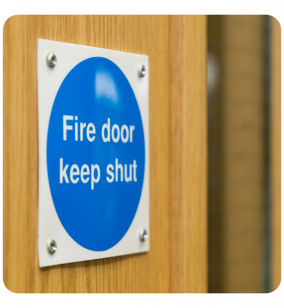 Fire door maintenance technician checking door alignment